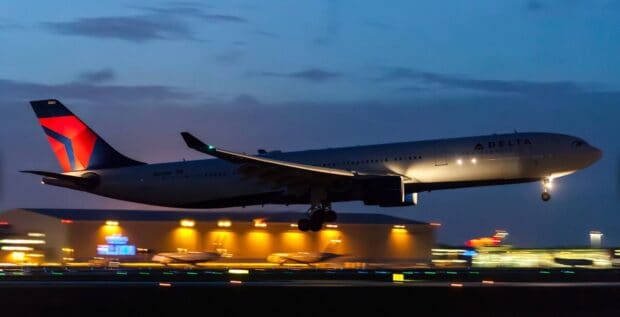 A Delta Air Lines plane is landing at the airport under the evening sky, HD Desktop Wallpaper