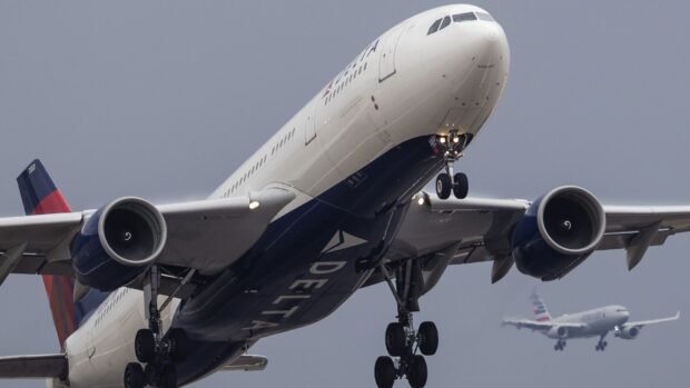 A large Delta Air Lines plane is captured taking off under a gray sky, HD Desktop Wallpaper