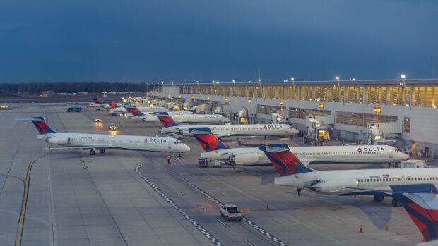 Several Delta Air Lines planes are parked at the terminal during twilight at the airport, HD Desktop Wallpaper