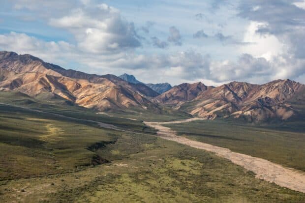 A scenic view of mountains and greenery in Denali National Park And Preserve under a cloudy sky, HD Desktop Wallpaper