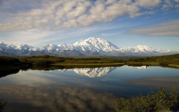 A scenic view of Denali National Park showing snow capped mountains reflected in a calm lake, 2K Desktop Wallpaper
