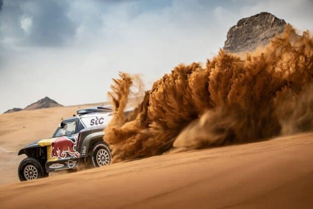 A rally raid vehicle speeds through sandy dunes creating a large dust cloud, HD Desktop Wallpaper