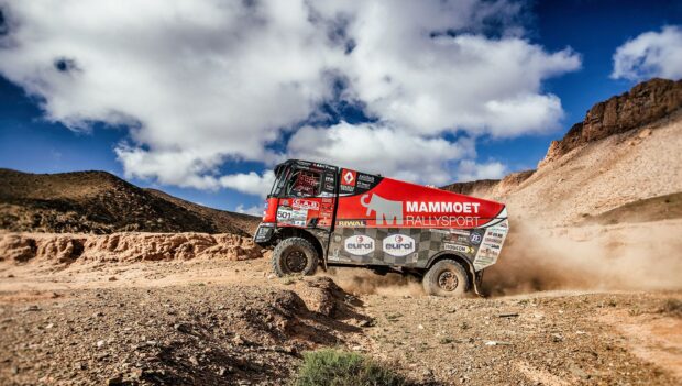 A rally raid truck drives through the desert terrain kicking up dust under a blue sky, HD Desktop Wallpaper