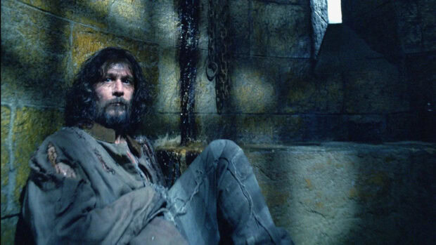 A man sits trapped in a stone prison cell wearing tattered clothes in The Prisoner Of Azkaban, HD Desktop Wallpaper