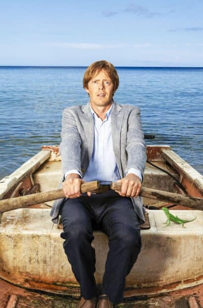A man rows a boat on calm water in the Death In Paradise tv series, HD Mobile Wallpaper