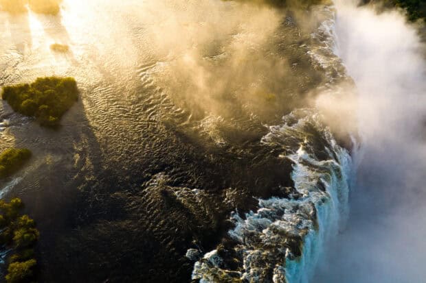 The Devils Pool in Zambia showcases a stunning river edge with mist, 2K Desktop Wallpaper