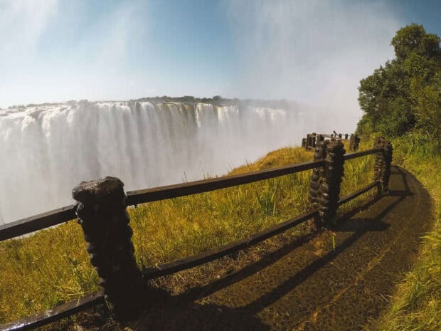 A path with a fence near the Devils Pool Zambia waterfall surrounded by greenery, HD Desktop Wallpaper
