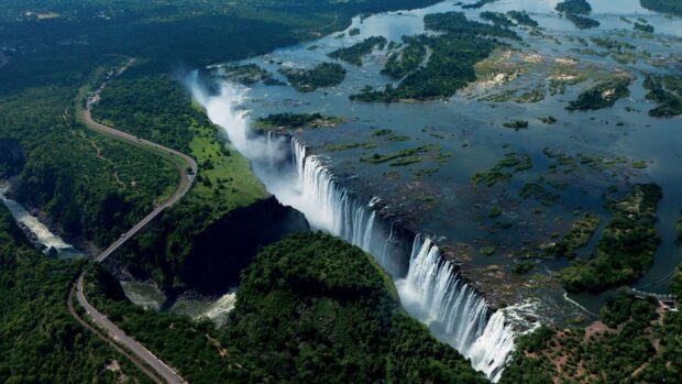 Aerial view of Devils Pool along the edge of Victoria Falls in Zambia surrounded by lush green forest, HD Desktop Wallpaper
