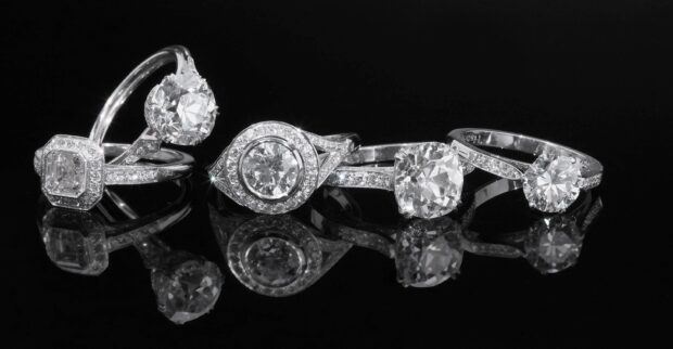 Diamond rings with intricate designs reflecting on black surface, 2K Desktop Wallpaper