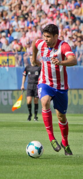 Diego Costa is running during a soccer match wearing his team's red and white jersey, 2K Mobile Wallpaper