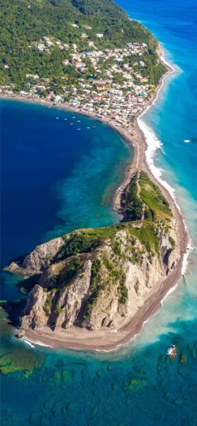 Aerial view of Dominica showing the coastal town with clear blue waters and lush greenery, 2K Phone Wallpaper