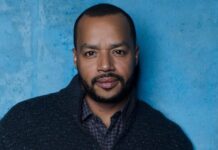 Donald Faison is posing in front of a blue textured wall wearing a dark jacket, HD Desktop Wallpaper