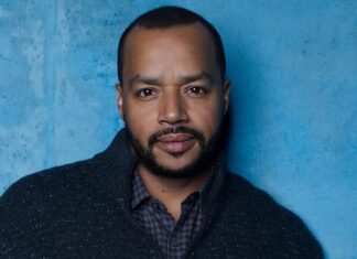 Donald Faison is posing in front of a blue textured wall wearing a dark jacket, HD Desktop Wallpaper