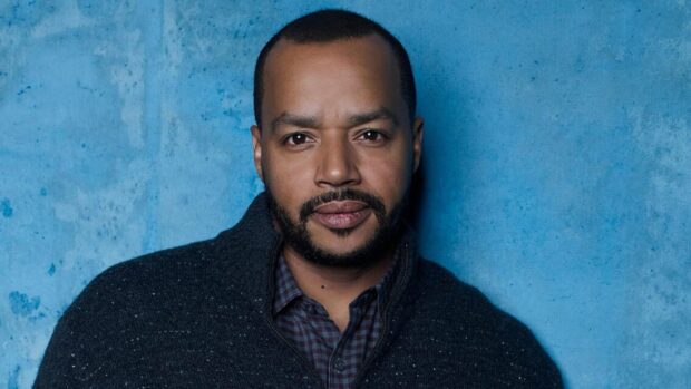 Donald Faison is posing in front of a blue textured wall wearing a dark jacket, HD Desktop Wallpaper