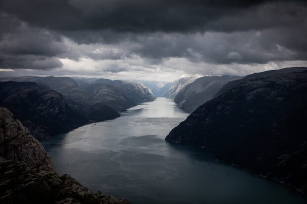 The Norwegian fjords stretch beneath dark clouds in this landscape, HD Desktop Wallpaper