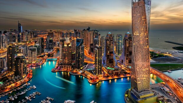 The Dubai skyline shows modern skyscrapers and waterways during sunset, 4K Desktop Wallpaper