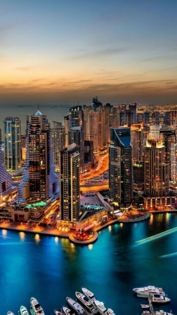 The United Arab Emirates skyline glows with city lights reflecting on the water during dusk, HD Phone Wallpaper
