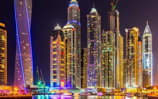 The Dubai skyline features illuminated skyscrapers and yachts reflecting at night in United Arab Emirates Wallpapers, 2K PC Wallpaper