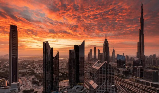 The United Arab Emirates skyline glows under a vibrant sunset sky with iconic modern skyscrapers, HD Desktop Wallpaper