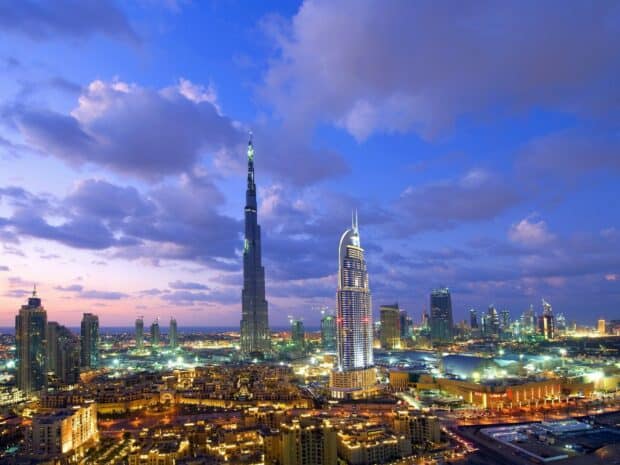 The Dubai skyline at sunset features Burj Khalifa and illuminated buildings in the United Arab Emirates, HD Desktop Wallpaper