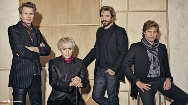The Duran Duran band members pose together in a stylish setting wearing black outfits, HD Desktop Wallpaper