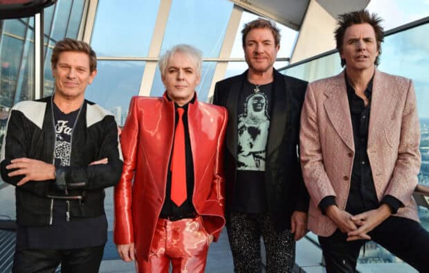The Duran Duran members wear distinctive outfits while posing on a balcony, HD Desktop Wallpaper