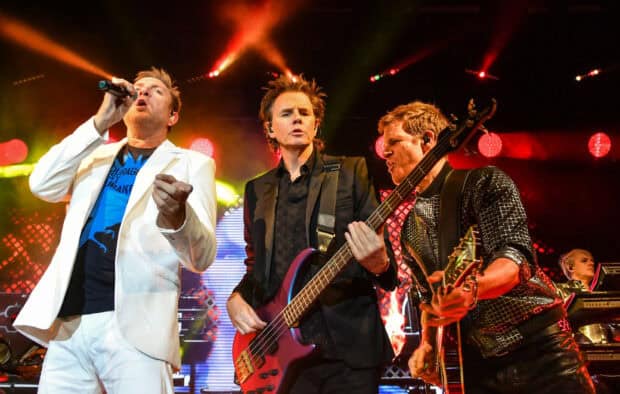 The Duran Duran band is performing live with vibrant stage lights and instruments, HD Desktop Wallpaper