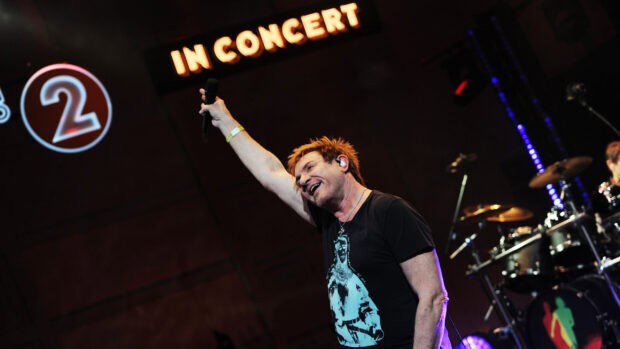 A singer raises his arm during a Duran Duran concert performance, 2K Desktop Wallpaper