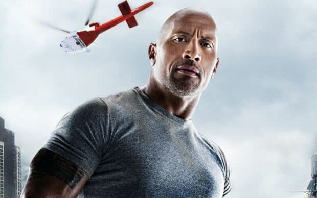 Dwayne Johnson is wearing a gray shirt with a helicopter flying behind him in the city, HD Desktop Wallpaper