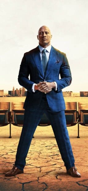 Dwayne Johnson stands confidently in a blue suit with a city background, HD Mobile Wallpaper