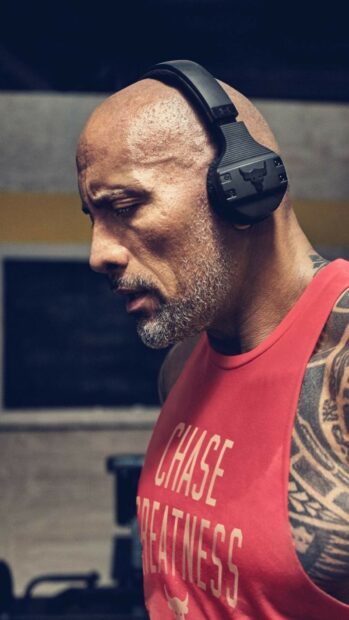 Dwayne Johnson is concentrated while wearing headphones and exercising intensely, HD Mobile Wallpaper