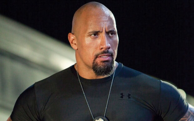 Dwayne Johnson wallpapers show him with a focused expression wearing a black shirt, HD Desktop Wallpaper