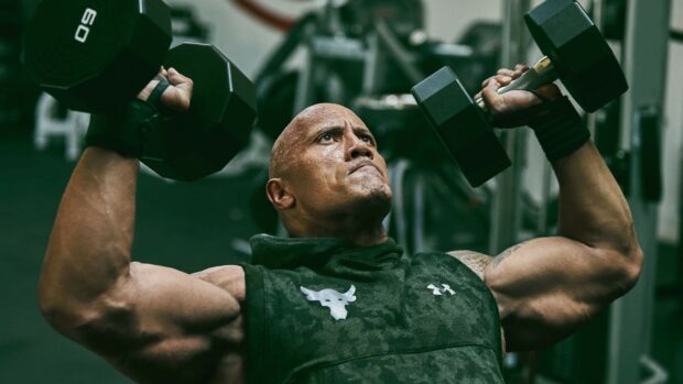 Dwayne Johnson is focused on lifting dumbbells during his workout session, HD Desktop Wallpaper