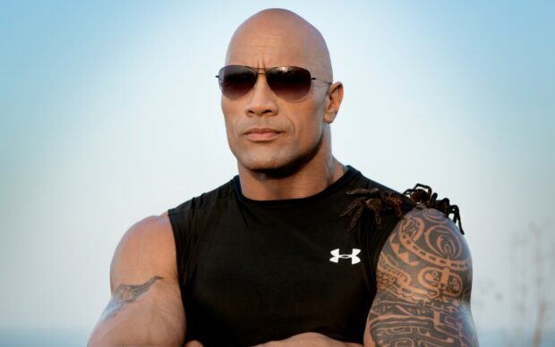 Dwayne Johnson stands with arms crossed wearing sunglasses outdoors, 2K Desktop Wallpaper