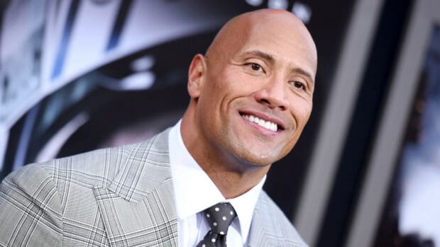 Dwayne Johnson smiling in a gray suit with polka dot tie at an event, HD Desktop Wallpaper