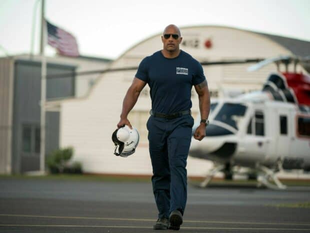 Dwayne Johnson walking confidently holding a helmet near a helicopter, HD Desktop Wallpaper