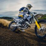 A rider on an enduro motorbike kicks up dirt as they navigate the trail, HD Desktop Wallpaper