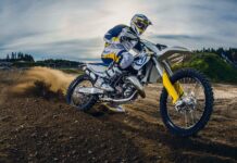 A rider on an enduro motorbike kicks up dirt as they navigate the trail, HD Desktop Wallpaper