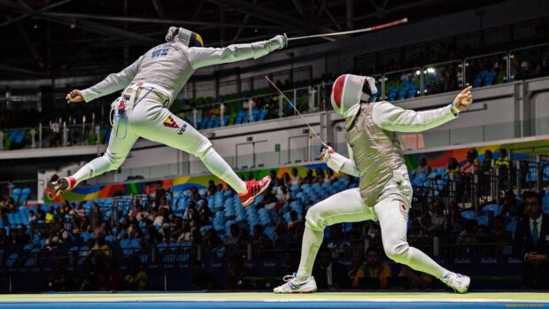 A dynamic moment of a fencing match shows two athletes in action with swords, HD Desktop Wallpaper