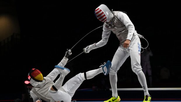 Two fencers compete intensely during a match with protective gear, 2K Desktop Wallpaper