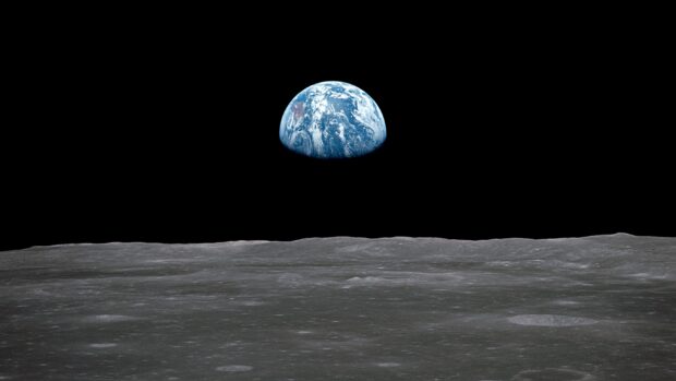 The Earth rises above the lunar surface showing a stunning view from Apollo 13 mission, 2K Desktop Wallpaper