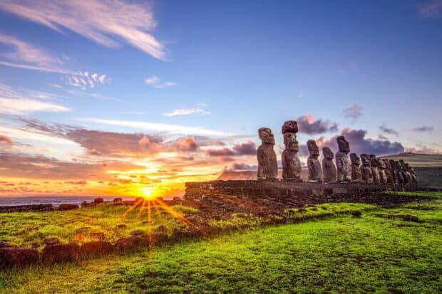 The Easter Island statues stand in a row with the sun setting behind them, casting vibrant colors, HD Desktop Wallpaper