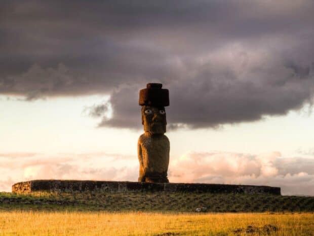 The Easter Island statue stands tall under a cloudy sky at sunset with grassy fields surrounding it, HD Desktop Wallpaper