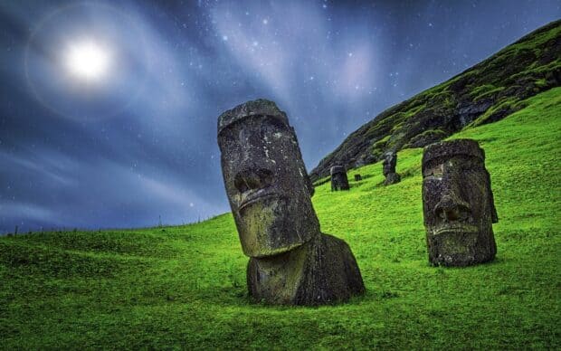 The Easter Island statues stand on grassy hills illuminated by moonlight and stars, HD Desktop Wallpaper