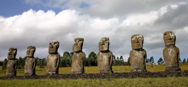 A row of Easter Island statues stands on a stone platform under a cloudy sky, 2K Desktop Wallpaper