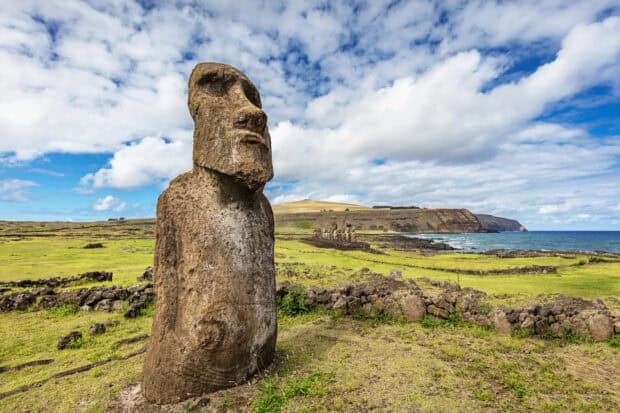 A stone statue stands on Easter Island with grassy fields and ocean in the background, HD Desktop Wallpaper