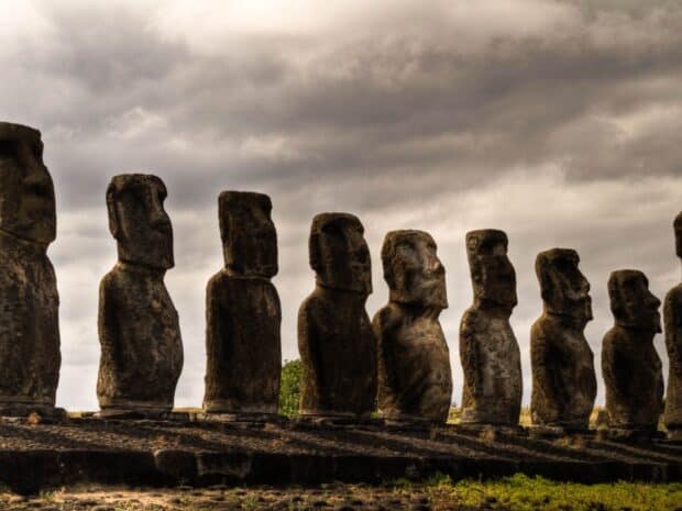 A row of Easter Island stone statues stands under a cloudy sky, HD Desktop Wallpaper