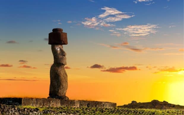 A Moai statue stands at sunset on Easter Island surrounded by natural landscape and colorful sky, HD Desktop Wallpaper