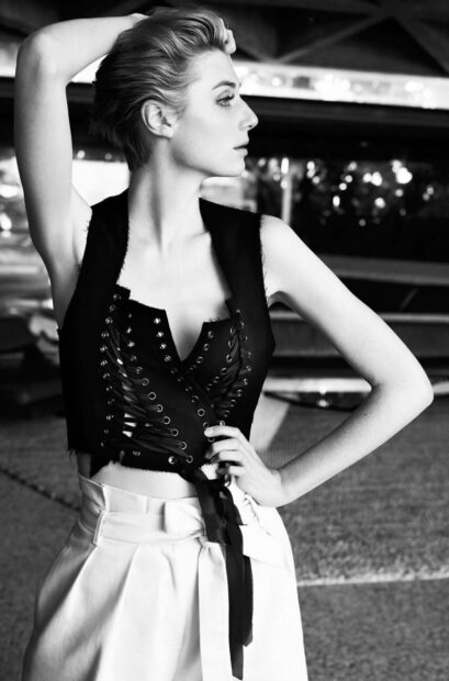 A black and white portrait of Elizabeth Debicki posing with one arm raised and wearing a stylish outfit, HD Mobile Wallpaper