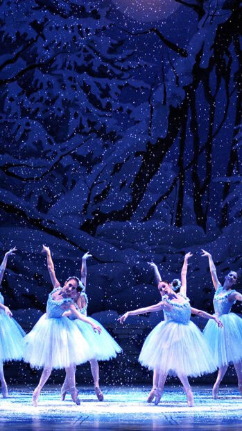 Ballet dancers gracefully perform under falling snow during a stage show, HD Phone Wallpaper